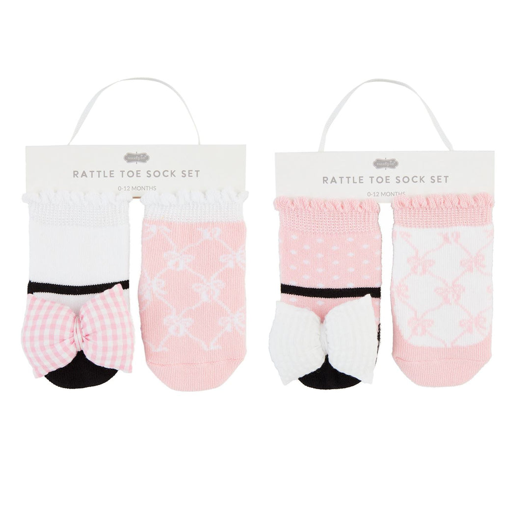 Two sets of baby toe socks with bow details, one set in pink with a floral pattern and the other in a solid white color.