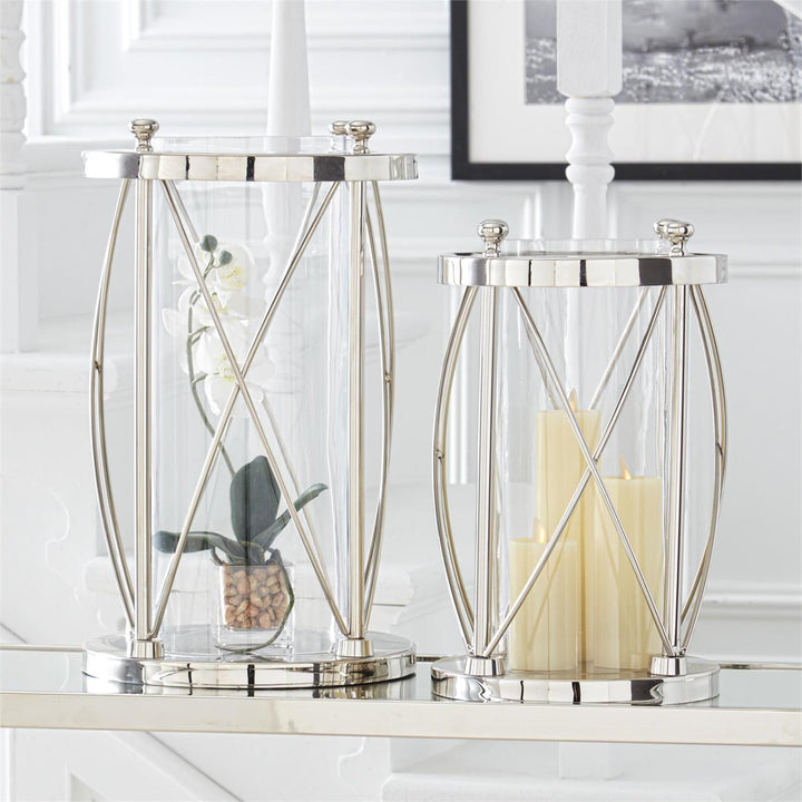 Decorative glass lanterns with metal frames on a white surface.