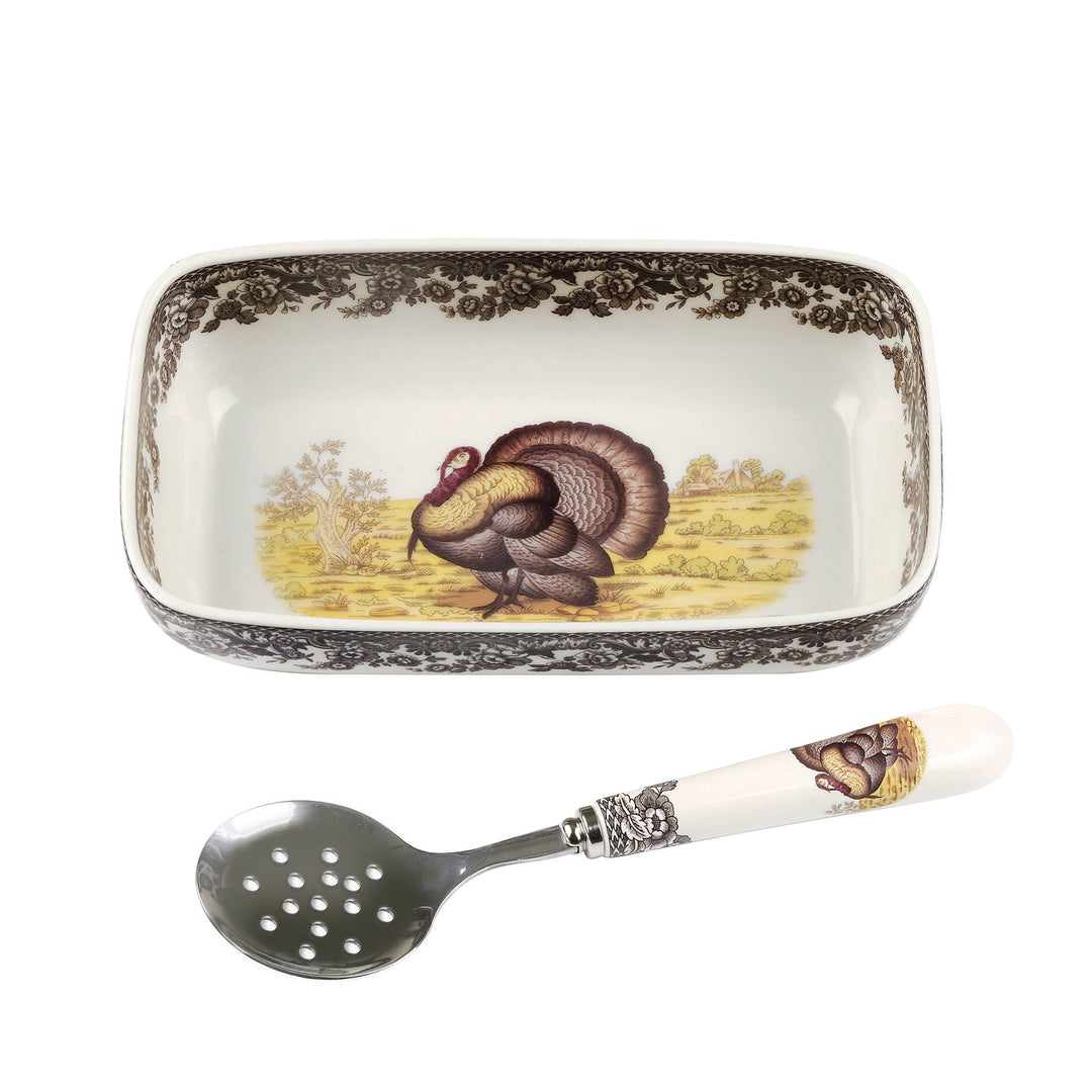 A fine earthenware cranberry dish with a slotted spoon, both featuring a turkey design, likely made for the Thanksgiving market.