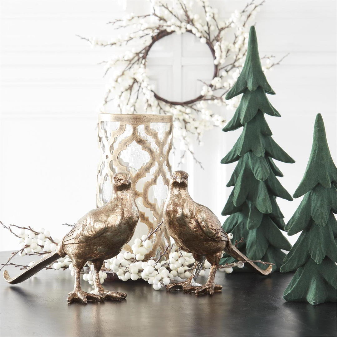 Decorative elements including birds, a lantern, and trees on a reflective surface with a white background.