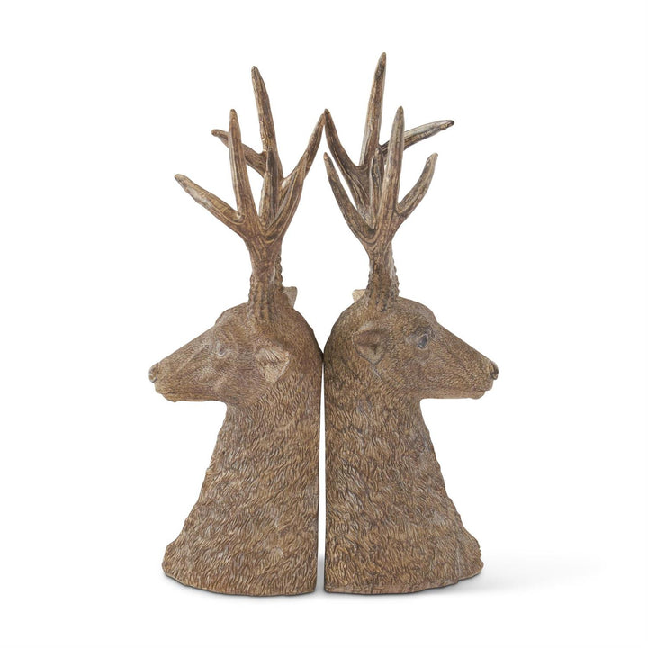 Two deer head sculptures with antlers on a white background