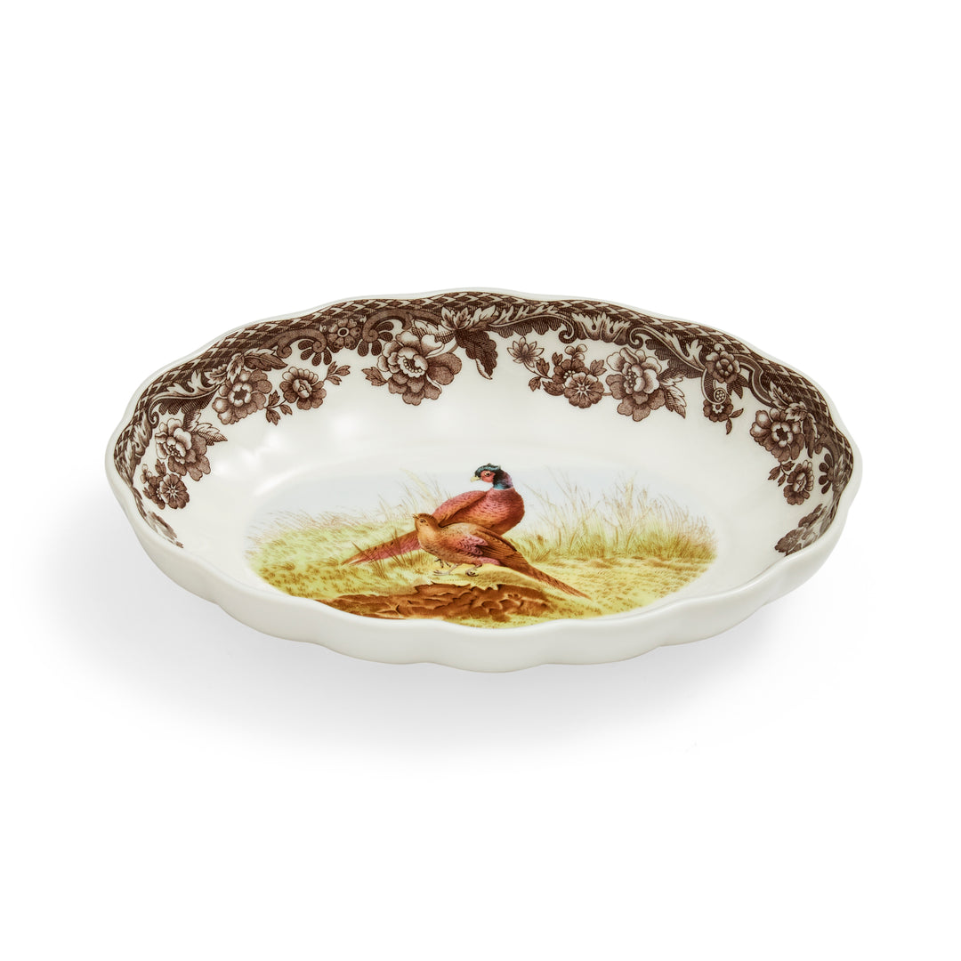 An oval fluted dish with a floral pattern and a central image of a pheasant.