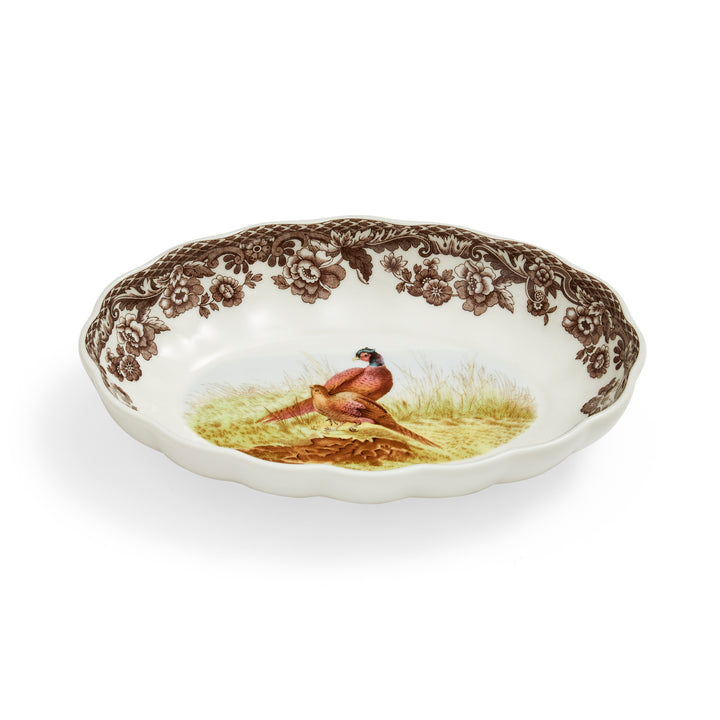 An oval fluted dish with a floral pattern and a central image of a pheasant.