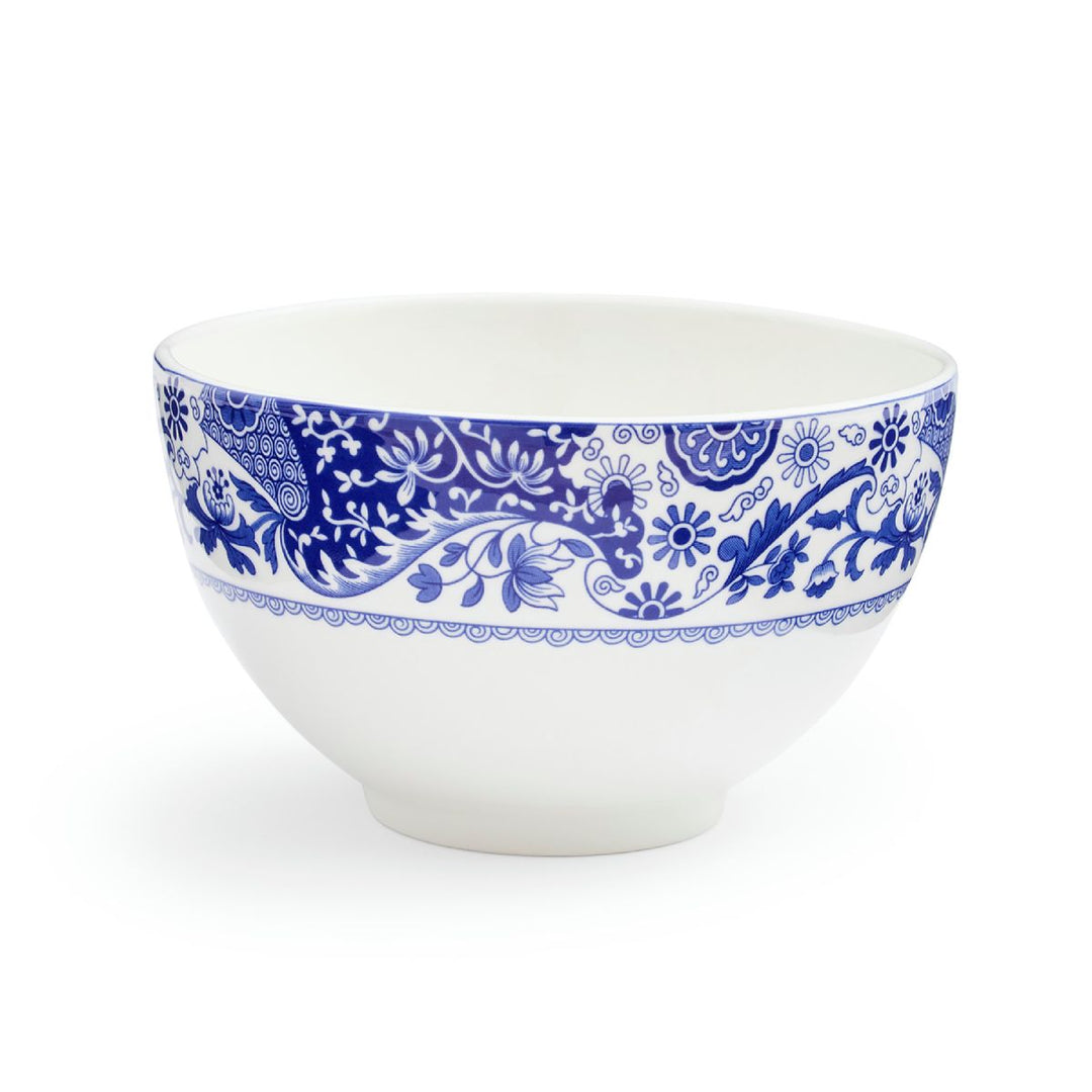 A white porcelain rice bowl with blue floral patterns on the exterior.
