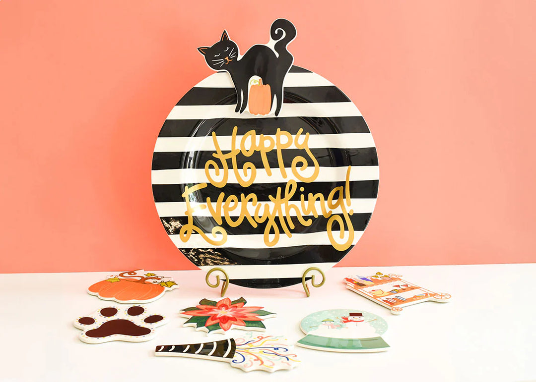 Decorative plate with black and white striped design, cat illustration, and 'Happy Everything!' text on a pink background.