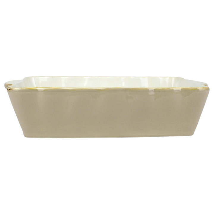 A rectangular Italian stoneware baker with scalloped edges and a gold rim.