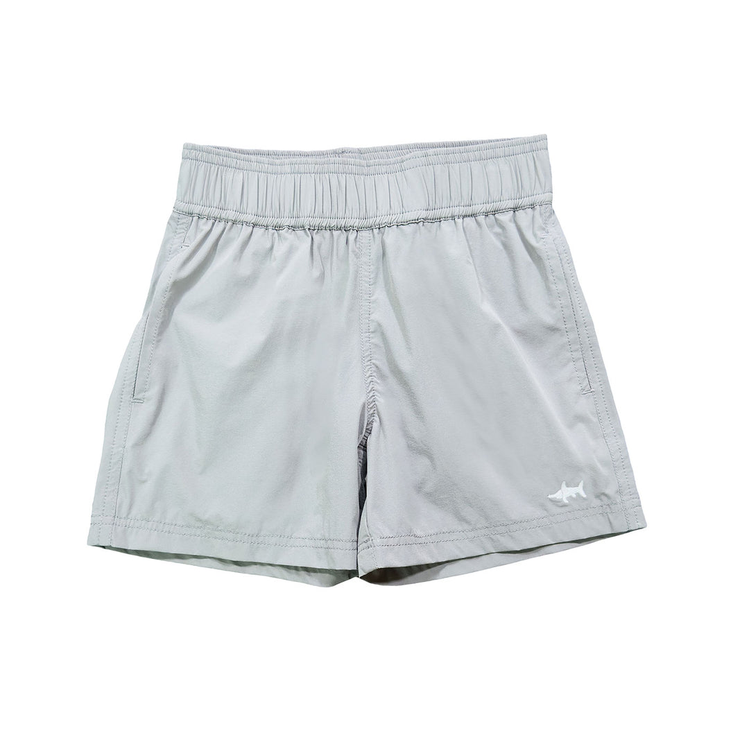 A pair of grey performance shorts for boys, with a small shark graphic on the left leg.