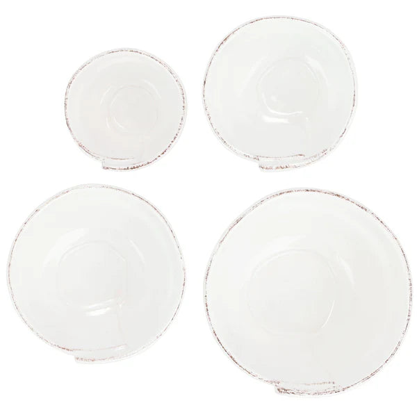 Set of four white ceramic bowls with subtle texture on a white background