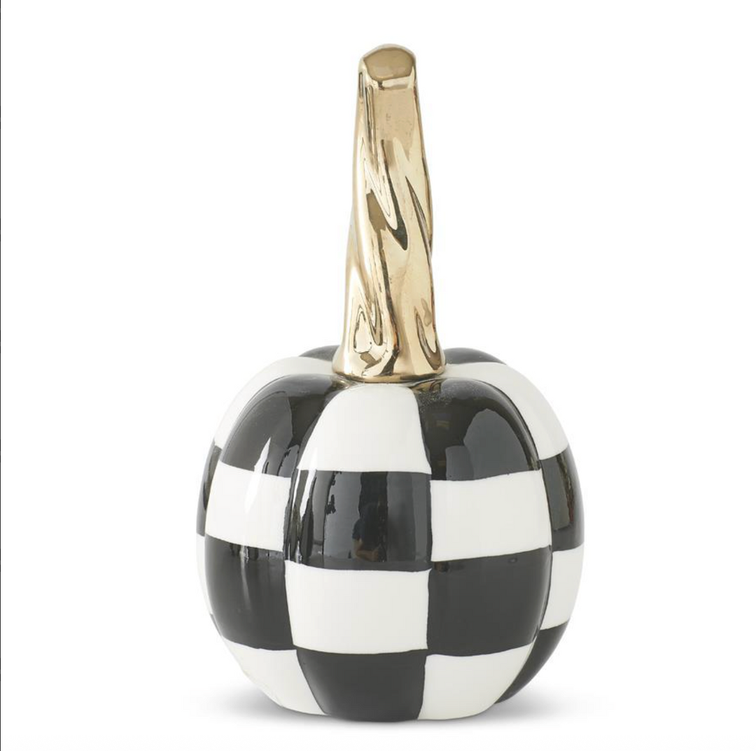 Decorative pumpkin with black and white checkered pattern and gold stem on a white background
