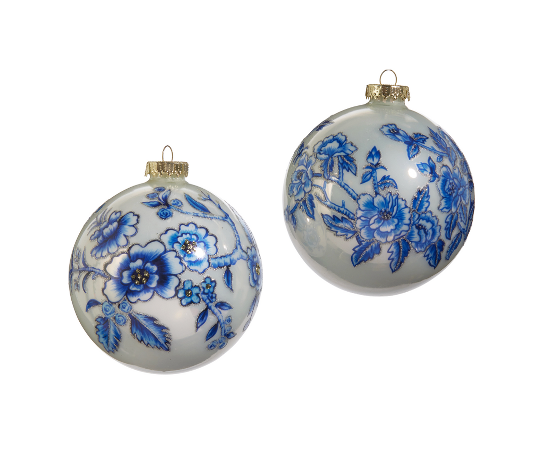 Two white Christmas ornaments with blue floral patterns on a white background