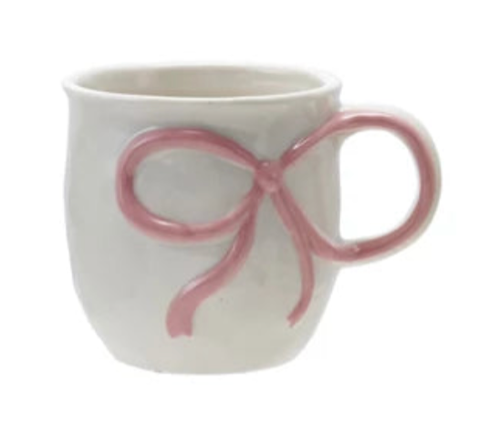 White mug with a pink bow design on a white background