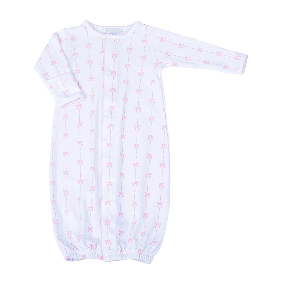 White baby gown with pink bow pattern on a white background