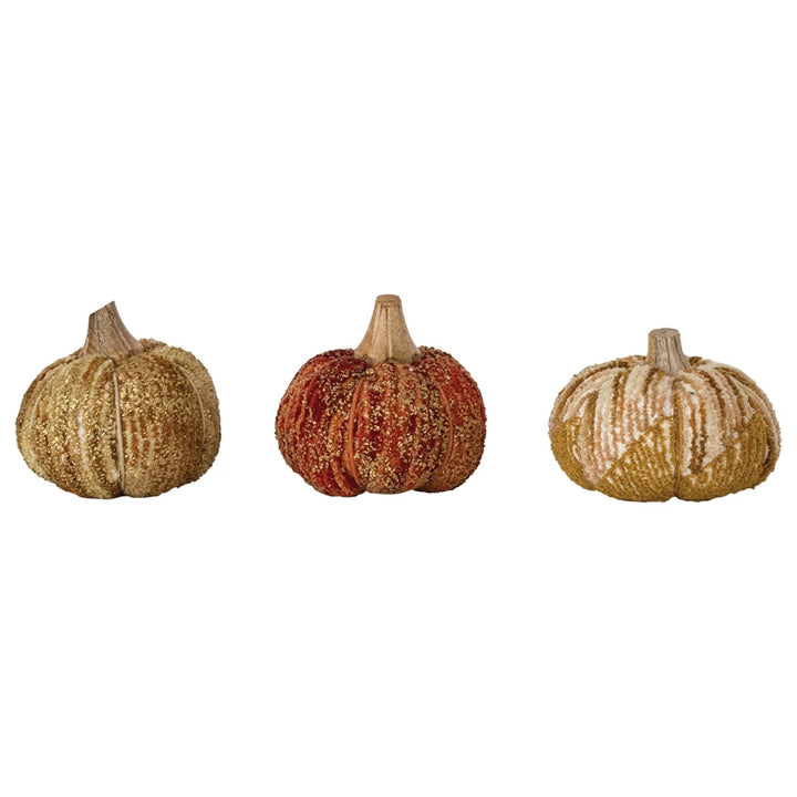Three decorative pumpkins with textured surfaces on a white background