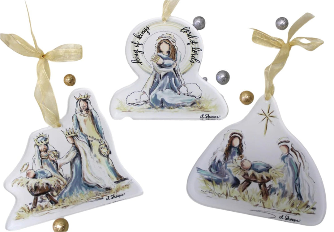 A set of three hand-painted acrylic nativity ornaments, featuring a Christmas tree, a nativity scene, and a winter landscape, adorned with gold ribbon and bead decorations.