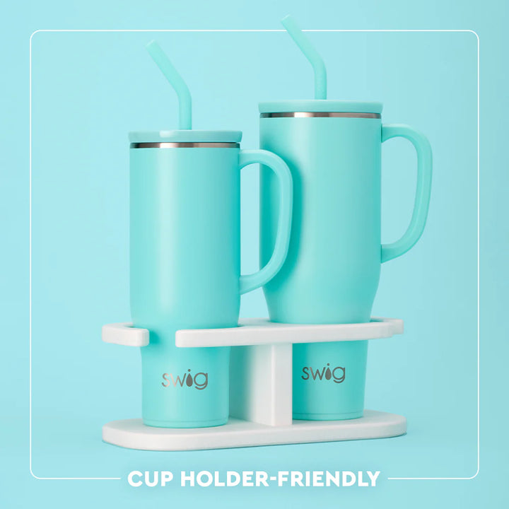 Two turquoise mugs with handles on a white swig cup holder against a light blue background.