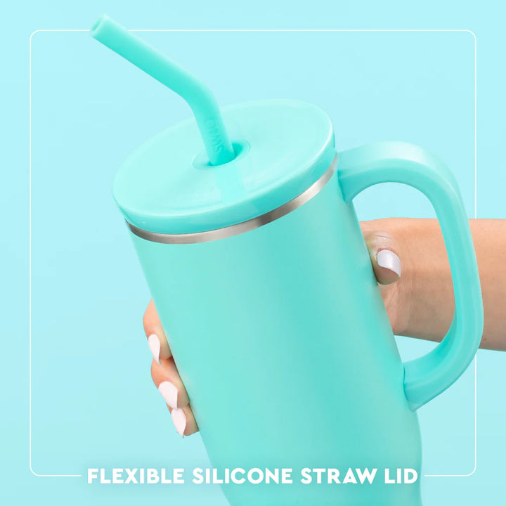 Turquoise mug with handle and flexible silicone straw lid against a light blue background