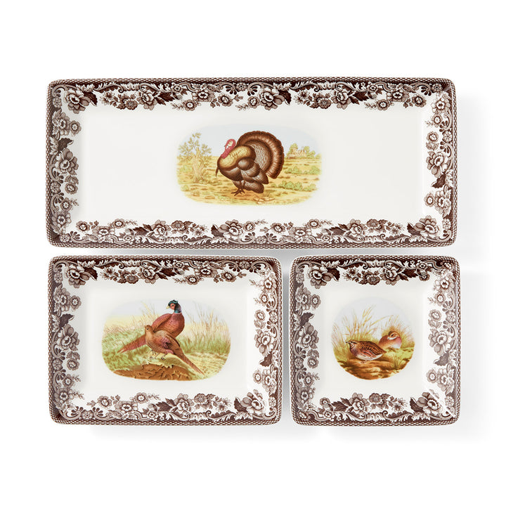 A set of three porcelain nesting trays with a woodland animal pattern, including a turkey and other birds, surrounded by a brown leaf design.