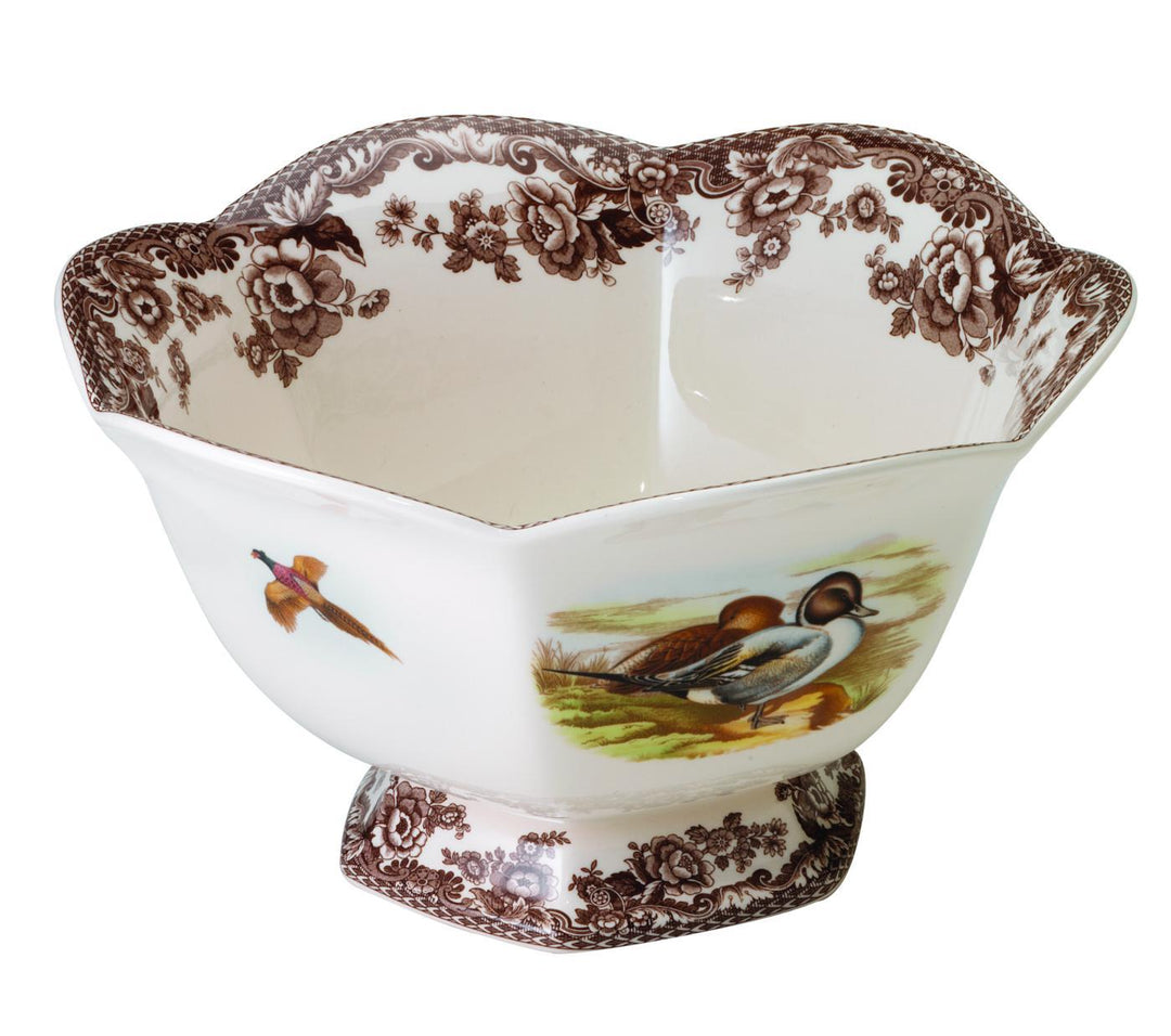 A blue and white hexagonal footed bowl with a floral and wildlife pattern, including an image of a bird perched on a branch.