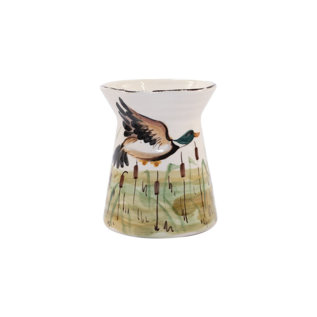 A ceramic utensil holder with a wildlife mallard design, featuring a bird in flight above a body of water.