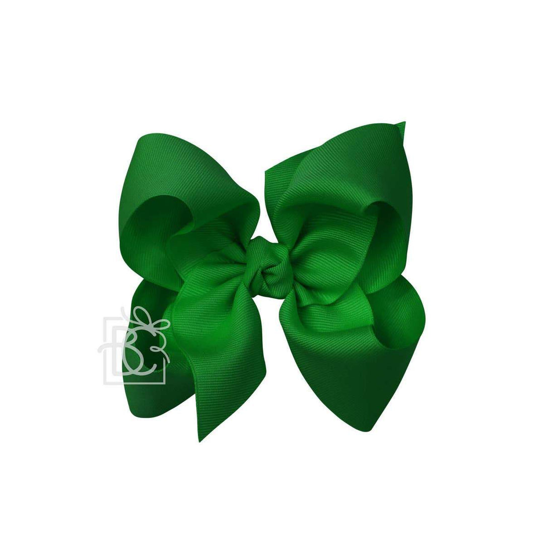 A green hair bow against a white background.