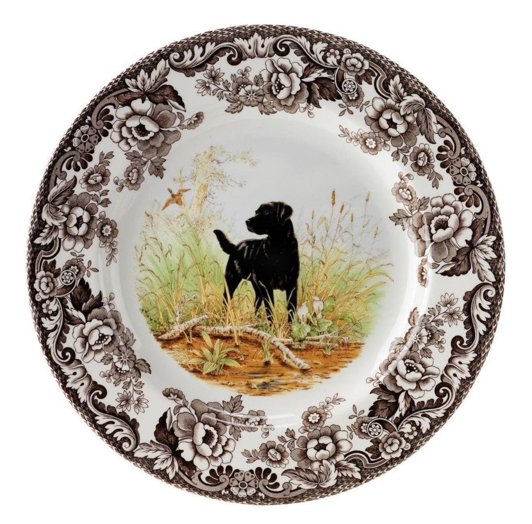 A Spode woodland salad plate with a black and white design featuring a dog in a field, surrounded by floral patterns.