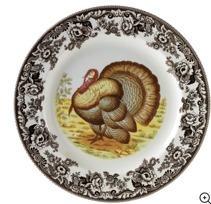 A Spode woodland salad plate with a black and white design featuring a dog in a field, surrounded by floral patterns.