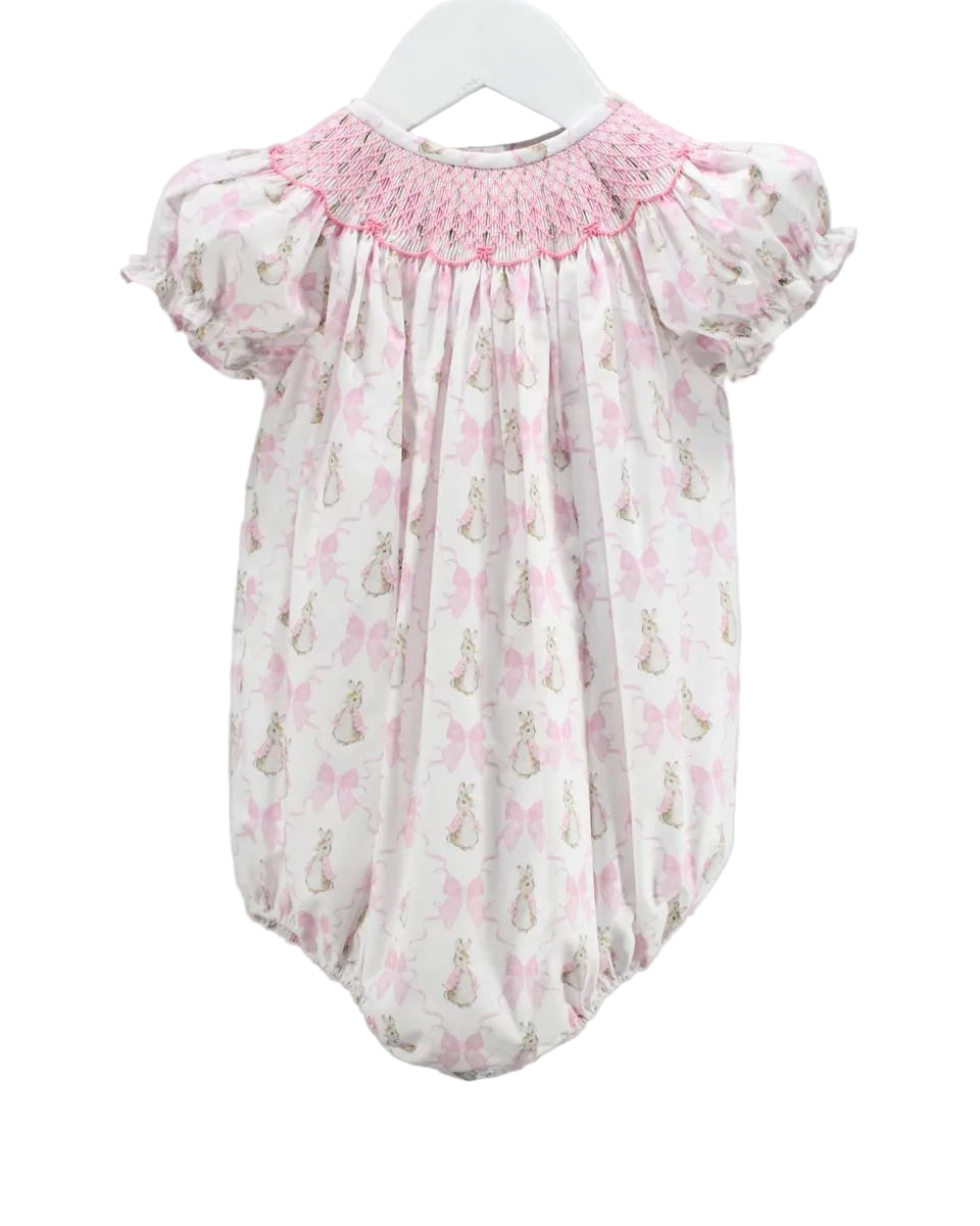 LITTLE GIRLS BUBBLE WITH PINK SMOCKED NECKLINE AND BUNNY AND BOW MOTIFS ON WHITE BACKGROUND