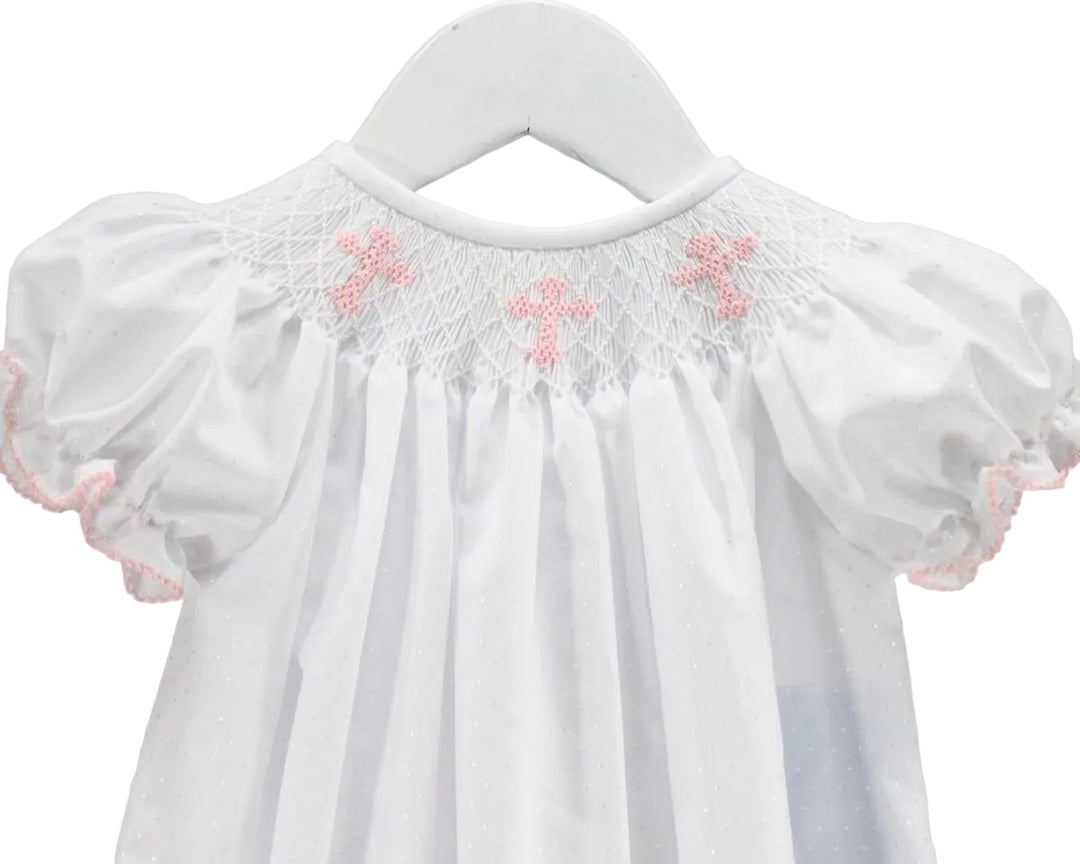 CLOSE UP DETAIL VIEW OF SMOCKED CROSSES ON BABY GIRL BUBBLE