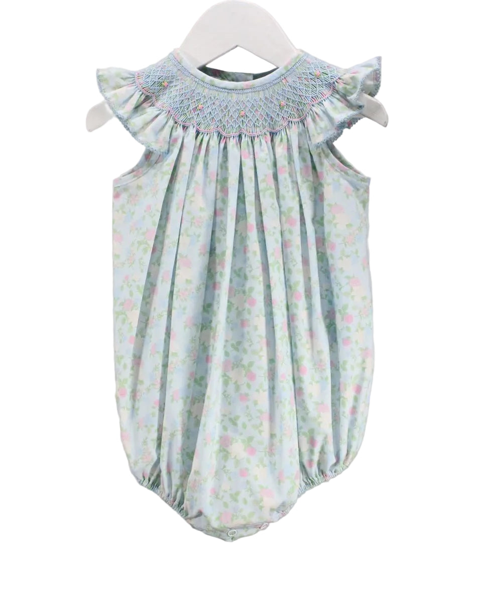 BLUE LITTLE GIRLS BUBBLE WITH FLORAL DETAIL AND SMOCKED NECKLINE ON WHITE BACKGROUND