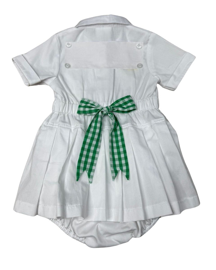 White baby dress with a green checkered bow on a white background
