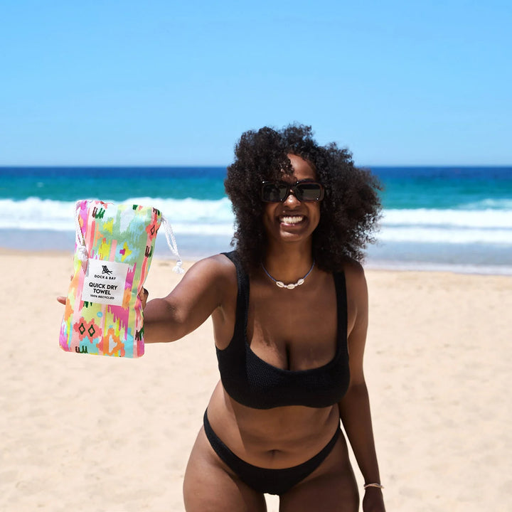 Woman on a beach holding a colorful product package