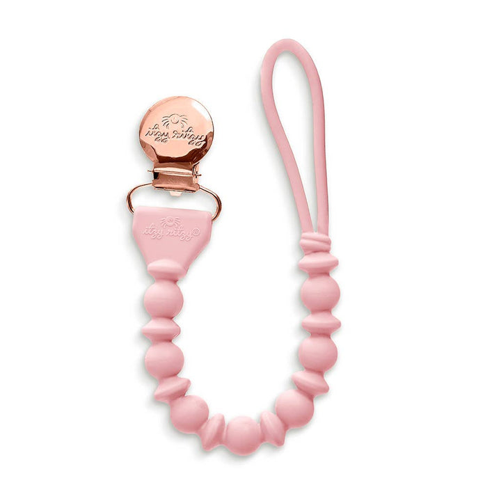 Pink pacifier clip with rose gold clasp on a white background