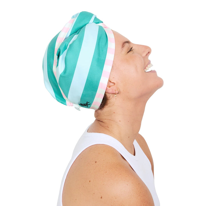 Woman wearing a green and white striped headscarf on a white background