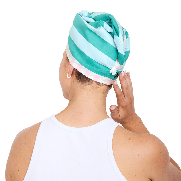 Person wearing a colorful striped headscarf on a white background