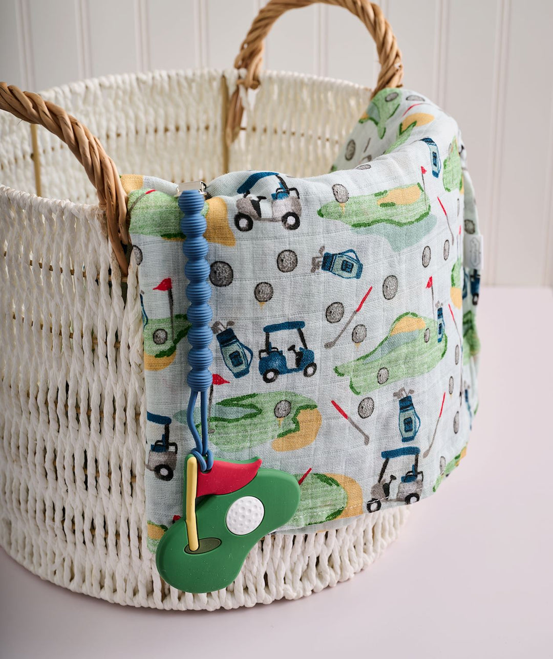 Woven basket with a fabric cover featuring golf-themed designs on a light background