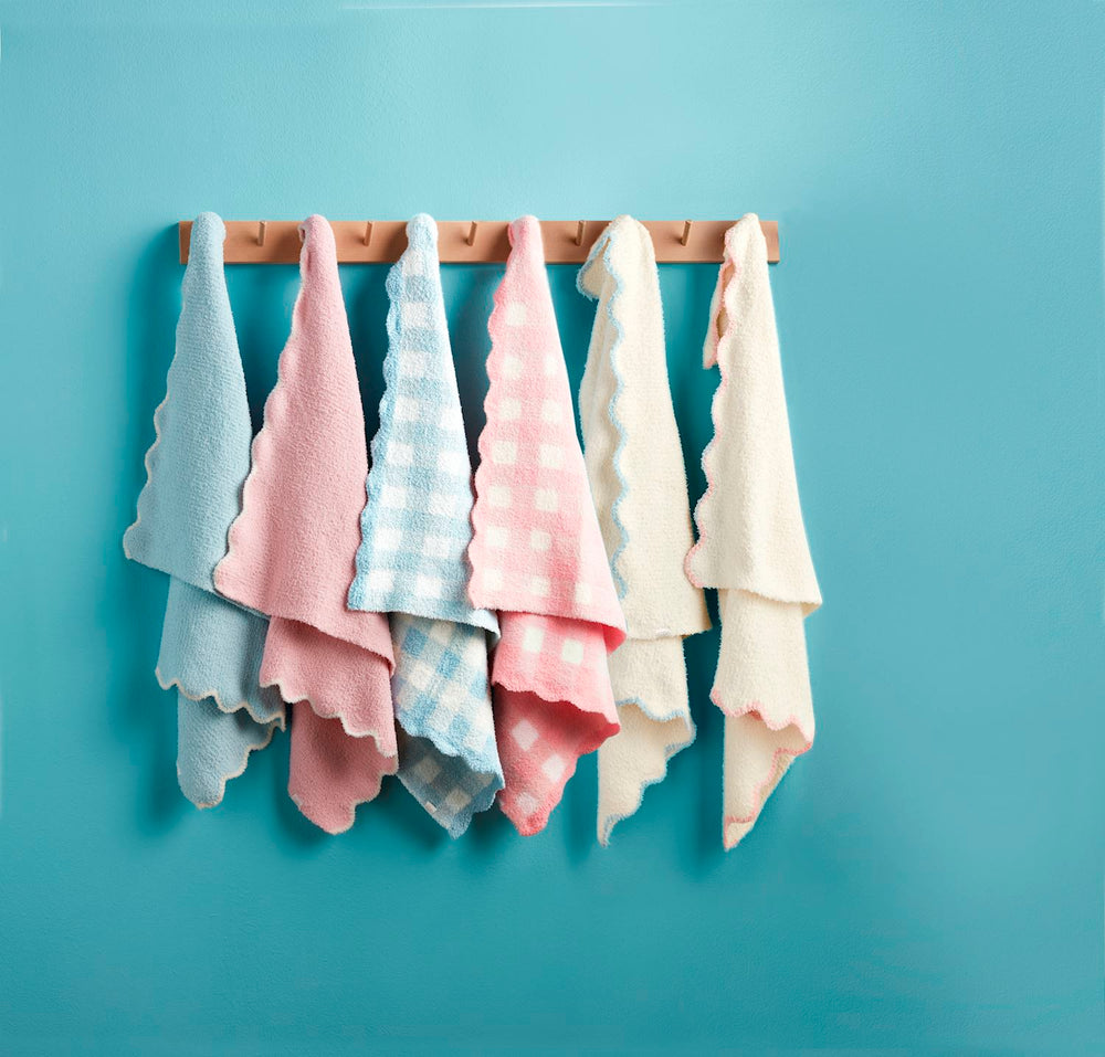 assortment of chenille blankets hanging from wall