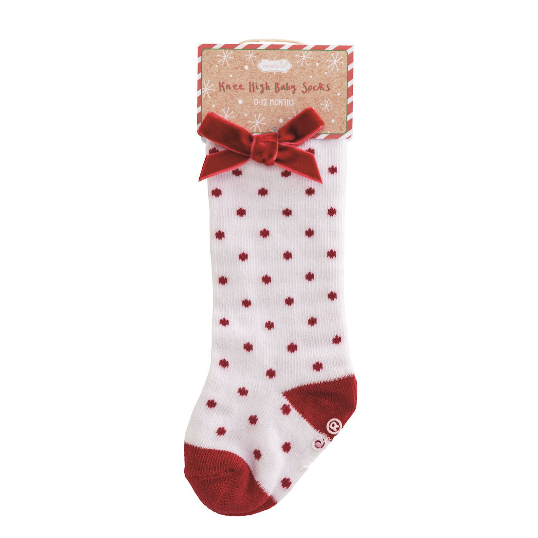A single white baby sock with red floral patterns, a red velvet bow, and red toe/heel sections, shown on a white background with its retail header card.