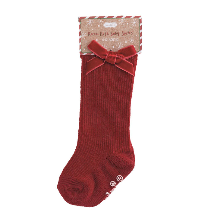 Red knee-high baby sock with a bow on a white background