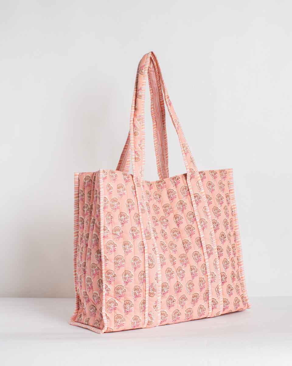 Pink tote bag with floral pattern on a white background