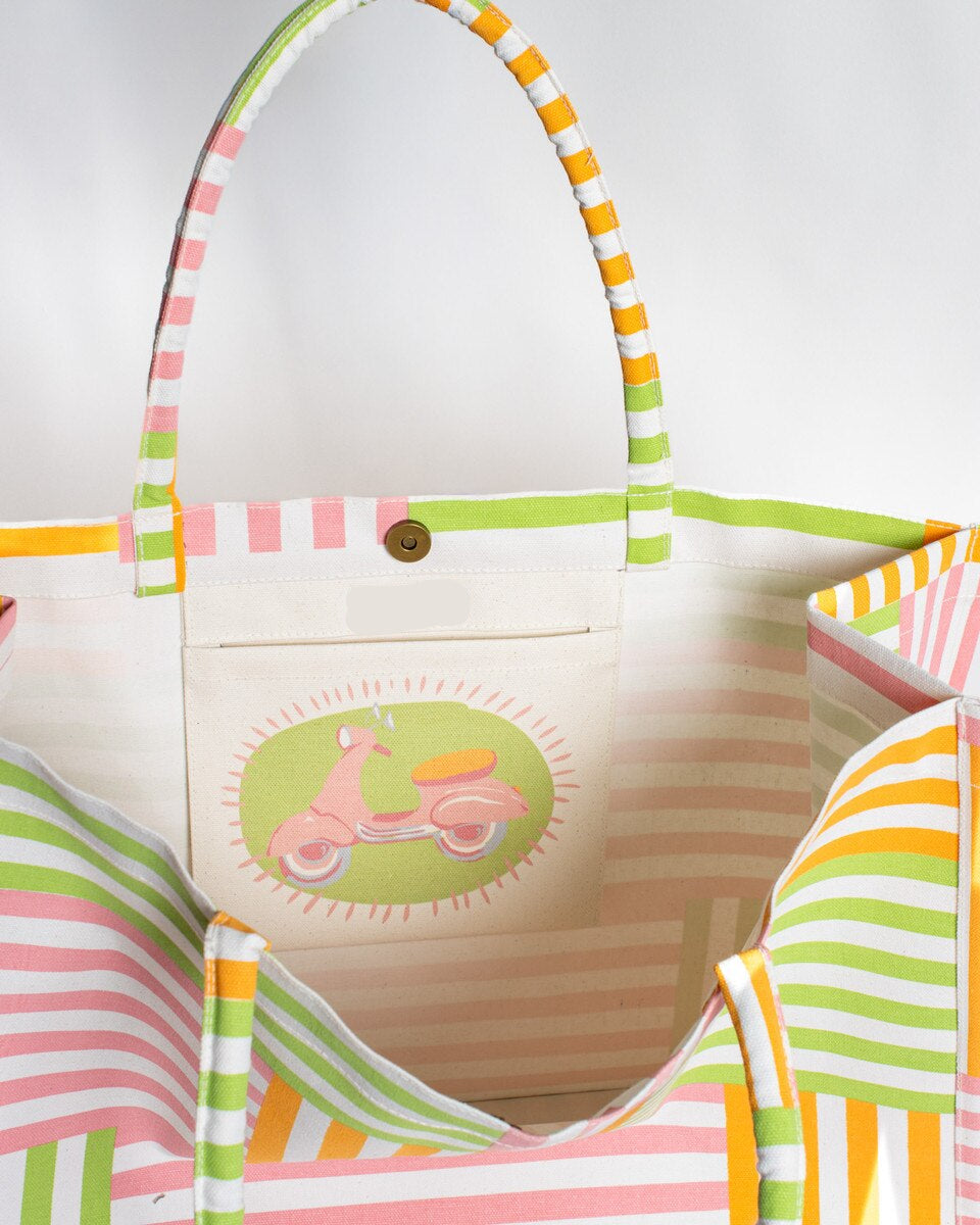 Colorful striped tote with a pink scooter design on the interior on a white background