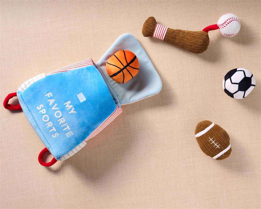 Children's soft book with toy sports items on a beige background