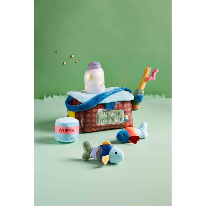 Toy fishing set with a boat, fishing rod, and fish on a green background
