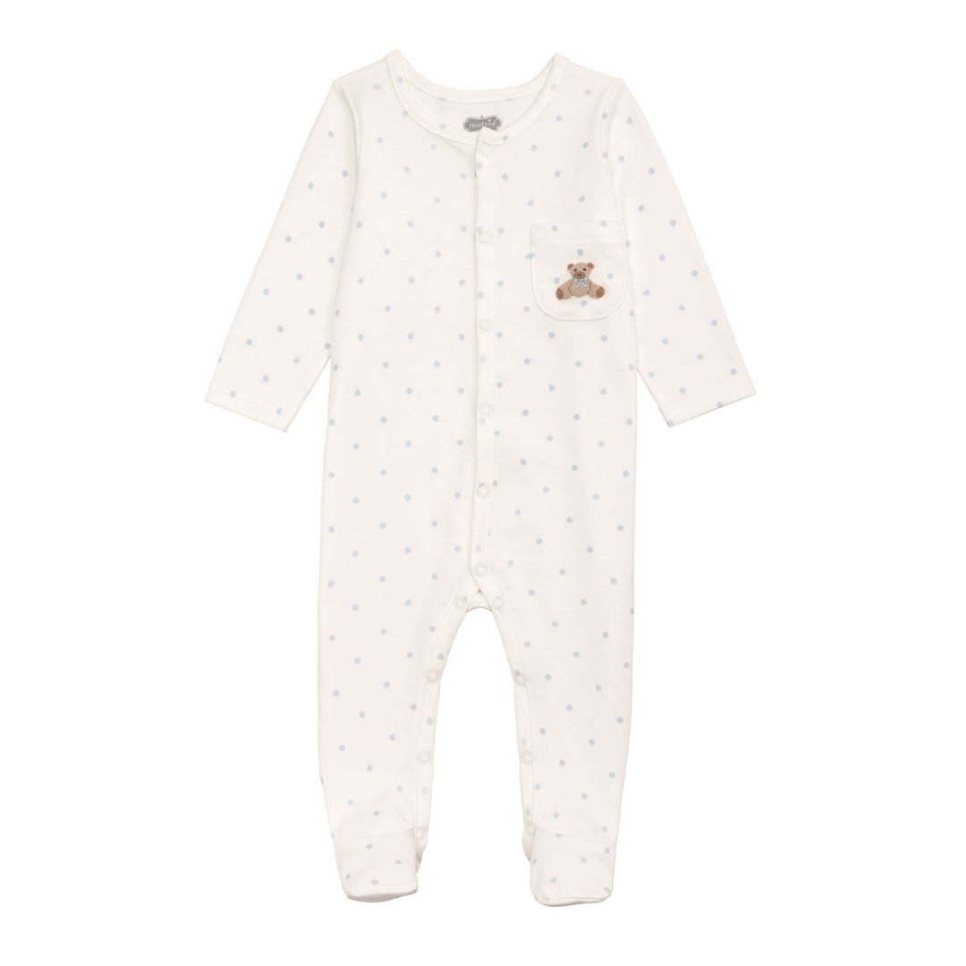 A baby long-sleeve footed sleeper in off-white with light blue polka dots and a small teddy bear patch on the chest pocket, shown on a plain white background.