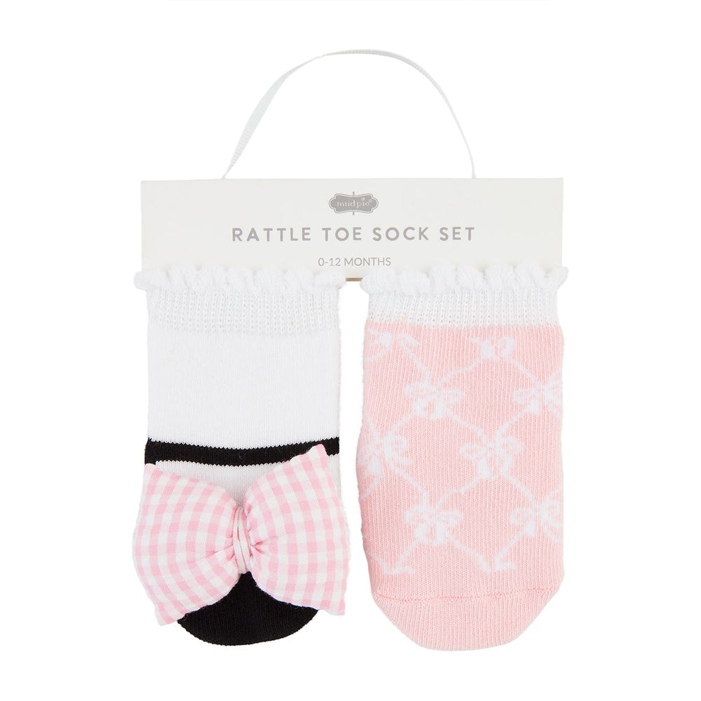 Two sets of baby toe socks with bow details, one set in pink with a floral pattern and the other in a solid white color.