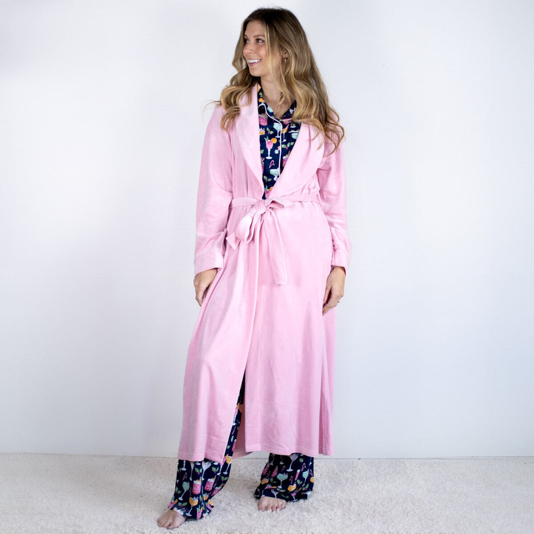 Woman wearing a pink robe and colorful pants on a white background