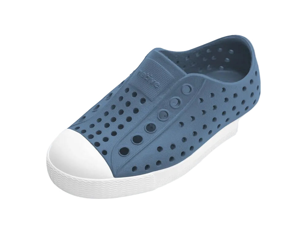 Blue slip-on shoe with white sole on a light white background