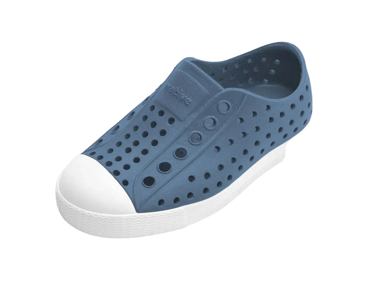 Blue slip-on shoe with white sole on a light white background
