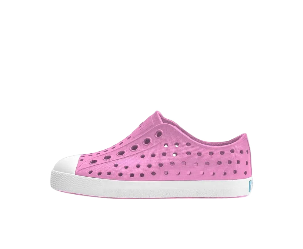Pink children's shoe with white sole on a white background