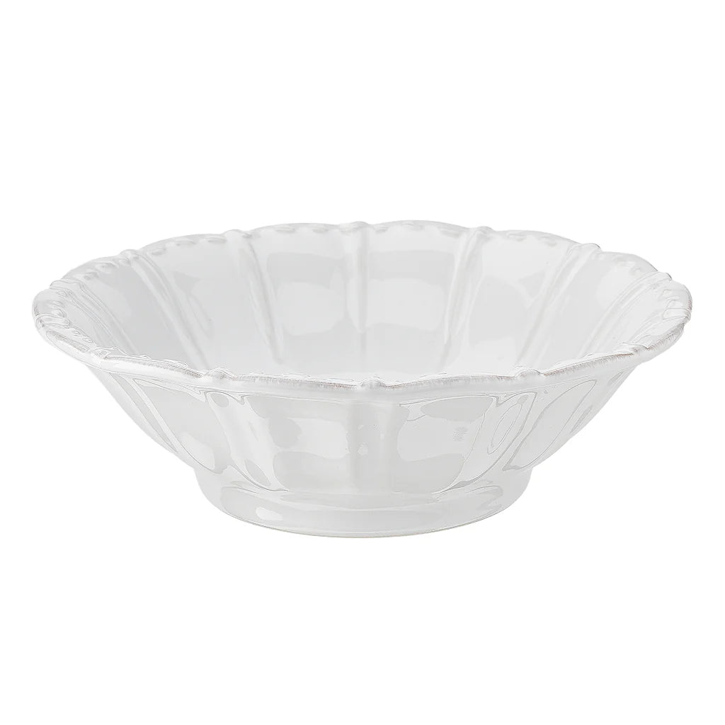 A white stoneware serving bowl with a scalloped edge design.