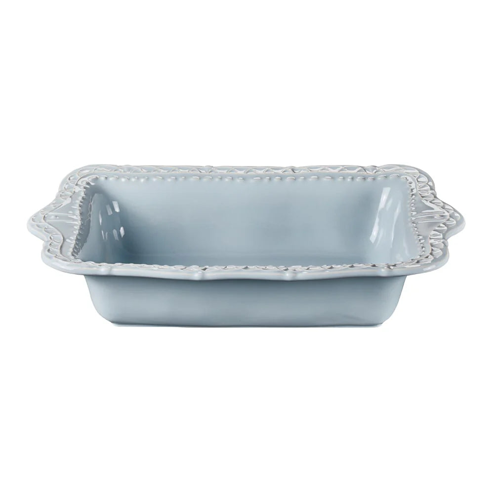 blue ceramic baking dish with decorative rim on a white background